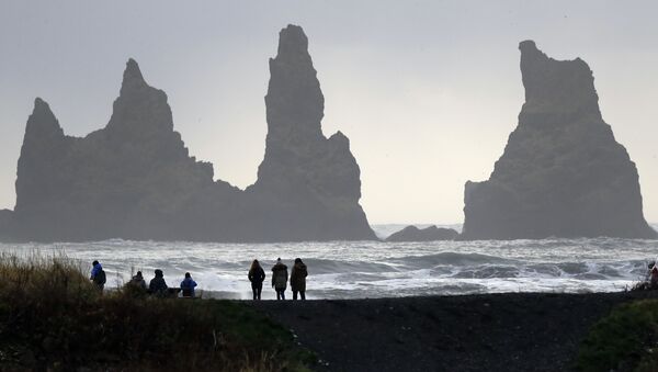 People walk on the black sanded beach in Vik, Iceland, near the Volcano Katla - Sputnik International