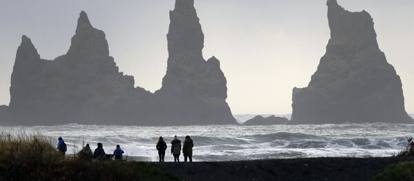 People walk on the black sanded beach in Vik, Iceland, near the Volcano Katla People walk on the black sanded beach in Vik, Iceland, near the Volcano Katla - Sputnik International