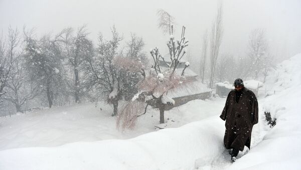 An Indian Kashmiri villager walks through snow in Gund, some 70km northeast from Srinagar - Sputnik International