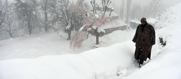 An Indian Kashmiri villager walks through snow in Gund, some 70km northeast from Srinagar An Indian Kashmiri villager walks through snow in Gund, some 70km northeast from Srinagar - Sputnik International