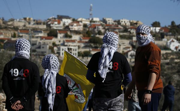 Palestinian protestors stand facing the Israeli settlement of Qadumim (Kedumim) during clashes with Israeli security forces following a demonstration against the expropriation of Palestinian land by Israel in the village of Kfar Qaddum, near Nablus, in the occupied West Bank on December 30, 2016 - Sputnik International