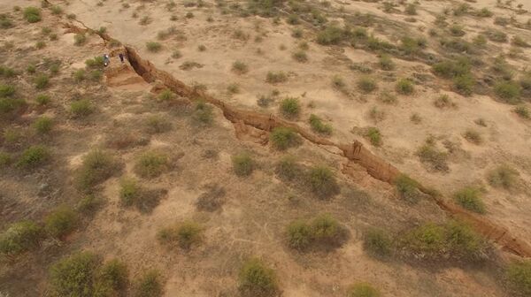 A 1.8 mile long fissure discovered in the Arizona desert. Those dots in the top left are geologist surveyors. A 1.8 mile long fissure discovered in the Arizona desert. Those dots in the top left are geologist surveyors. - Sputnik International