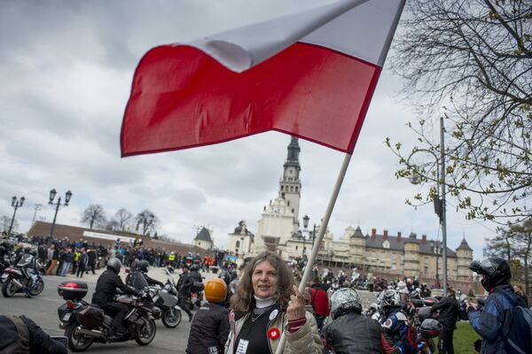 A woman waves a Polish flag in front of the Jasna Gora monastery during the annual Polish motorcyclists pilgrimage to the country's greatest place of pilgrimage hosting the Black Madonna of Czestochowa in Czestochowa, Poland, on April 19, 2015 - Sputnik International