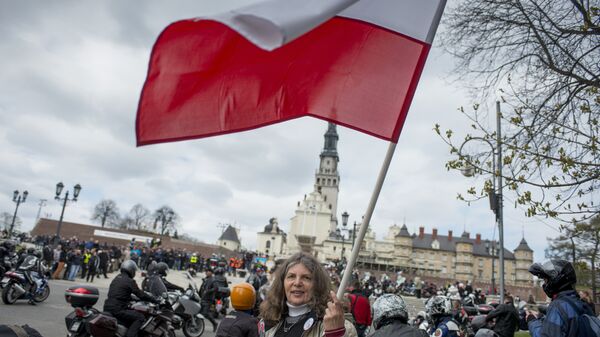 A woman waves a Polish flag in front of the Jasna Gora monastery during the annual Polish motorcyclists pilgrimage to the country's greatest place of pilgrimage hosting the Black Madonna of Czestochowa in Czestochowa, Poland, on April 19, 2015 - Sputnik International