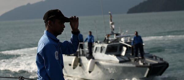 A Royal Malaysian Navy sailor (L) gestures as he stands aboard a naval ship during a search and rescue mission for boat-people, near the Thai-Malaysia border north of Langkawi island on May 28, 2015 A Royal Malaysian Navy sailor (L) gestures as he stands aboard a naval ship during a search and rescue mission for boat-people, near the Thai-Malaysia border north of Langkawi island on May 28, 2015 - Sputnik International