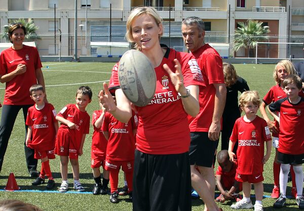 Princess Charlene of Monaco plays with the ball next to children of the Monaco rugby school as she visits the Monaco Rugby Union Club, on June 16, 2012 in Monaco, after she officially became patron of the AS Monaco Rugby Club - Sputnik International