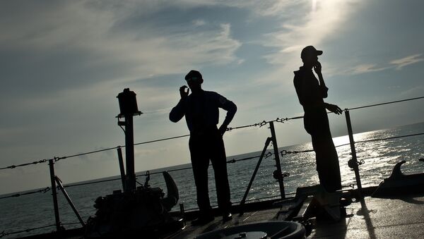 Royal Malaysian Navy personnel are silhoutted as they stand aboard a naval ship during a search and rescue mission for boat-people, near the Thai-Malaysia border north of Langkawi island on May 28, 2015 - Sputnik International