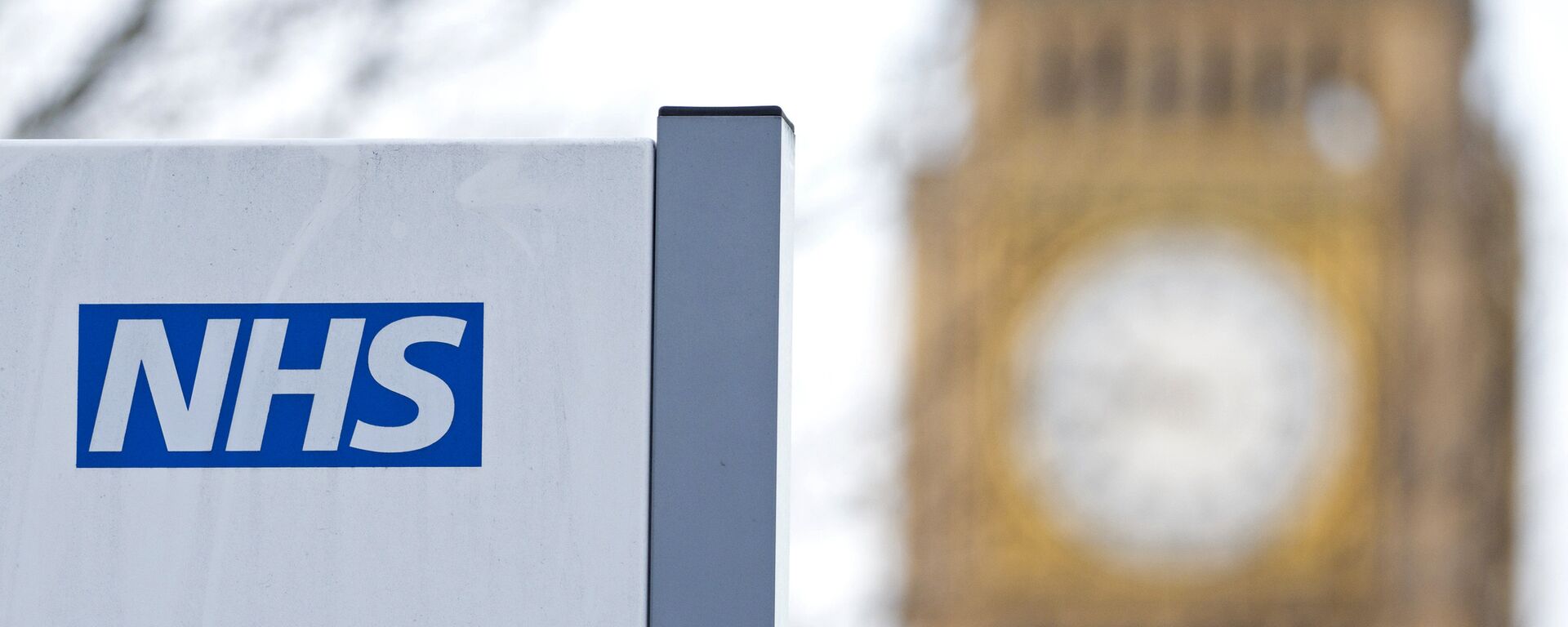 An NHS sign is pictured at St Thomas' Hospital in front of the Big Ben clock face and the Elizabeth Tower on January 13, 2017 in London.  - Sputnik International, 1920, 30.03.2022