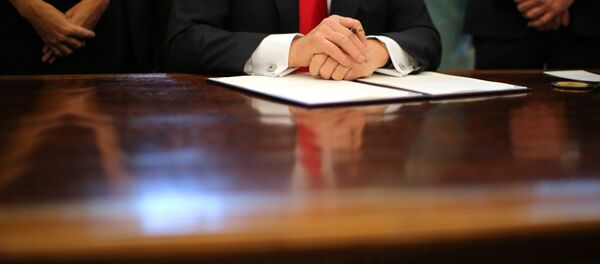 US President Donald Trump prepares to sign an executive order cutting regulations, accompanied by small business leaders at the Oval Office of the White House in Washington US, January 30, 2017. - Sputnik International