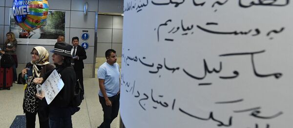 Silvia Sadjadi (L) who migrated from Iran, waits for a family member to arrive beside a arabic sign,after the immigration ban imposed by U.S Silvia Sadjadi (L) who migrated from Iran, waits for a family member to arrive beside a arabic sign,after the immigration ban imposed by U.S - Sputnik International