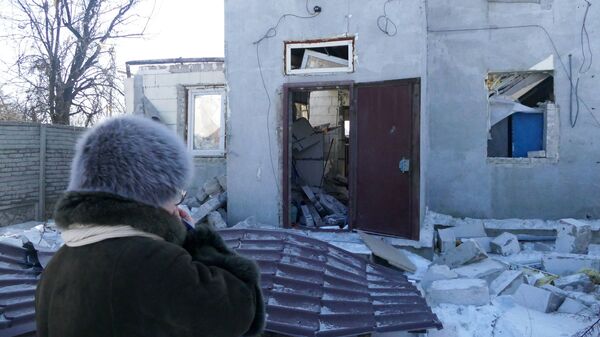 A woman by a house damaged by the shelling of the Ukrainian army in Makeevka, Donetsk Region. File photo  - Sputnik International