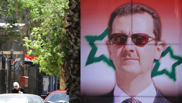 Poster bearing a portrait of President Bashar al-Assad - Sputnik International