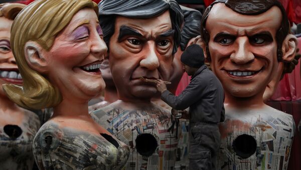A man puts the final touche on a giant figure depicting right-wing presidential candidates Francois Fillon (C) next to others depicting far right presidential candidate Marine Le Pen (L) and centrist independent presidential candidate Emmanuel Macron, on January 27, 2017 in Nice, southeastern France. - Sputnik International