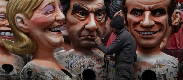A man puts the final touche on a giant figure depicting right-wing presidential candidates Francois Fillon (C) next to others depicting far right presidential candidate Marine Le Pen (L) and centrist independent presidential candidate Emmanuel Macron, on January 27, 2017 in Nice, southeastern France. - Sputnik International