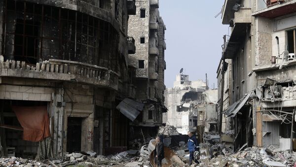 Syrians walk through the destruction in the old city of Aleppo, Syria - Sputnik International