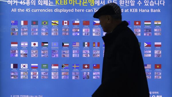 A man walks by a board displaying various banknotes issued in the world at a subway station in Seoul, South Korea. - Sputnik International