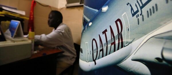 An image of a Qatar Airways plane is seen near an employee working at a travel agency in Khartoum, Sudan January 28, 2017 - Sputnik International