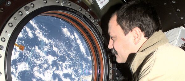 Cosmonaut Yury V. Usachev, Expedition Two mission commander, looks through the window on the Destiny laboratory onboard the International Space Station (ISS). - Sputnik International