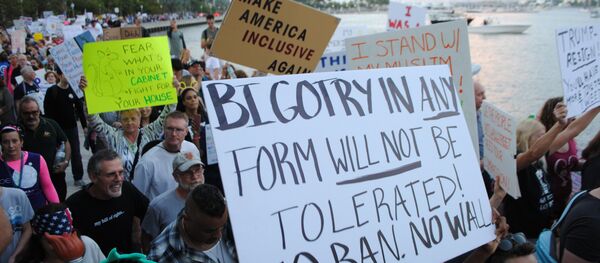 People protest outside the Trump Plaza Hotel against the executive orders issued by US President Donald Trump, February 4, 2017 in West Palm Beach, Florida - Sputnik International