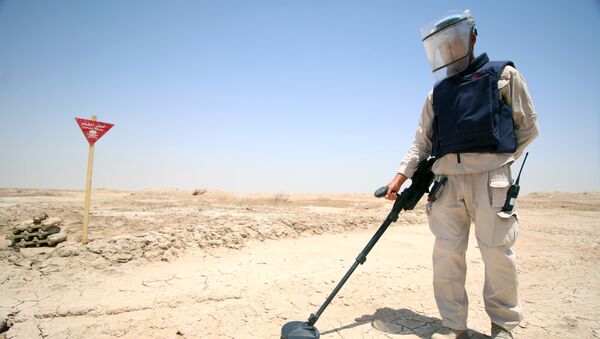 An Iraqi man wearing protective gear searches for landmines in the Shalamja border crossin, west of Basra, on the border between Iraq and Iran, on June 10, 2015 - Sputnik International