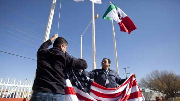 In this Friday, Dec. 27, 2013 photo, workers at one of maquiladoras of the TECMA group prepare to raise the U.S. flag along with the Mexican and TECMA flags in Ciudad Juarez, Mexico - Sputnik International