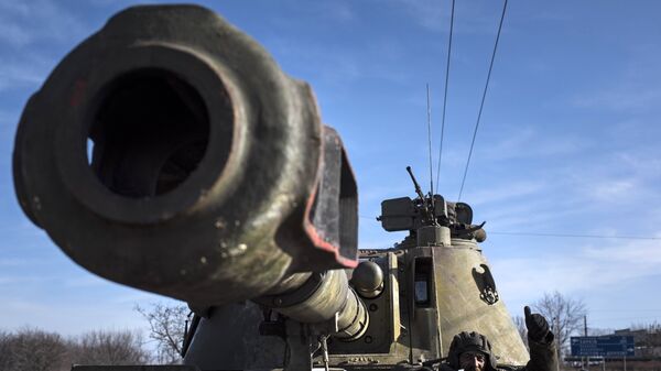 Ukrainian soldier smiles riding on a self-propelled artillery (File) - Sputnik International
