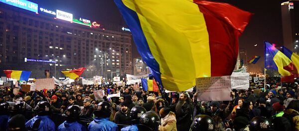 Romanian riot police stand guard as people demonstrate against controversial decrees to pardon corrupt politicians and decriminalize other offenses in front of the government headquarters in Bucharest, on February 1, 2017 Romanian riot police stand guard as people demonstrate against controversial decrees to pardon corrupt politicians and decriminalize other offenses in front of the government headquarters in Bucharest, on February 1, 2017 - Sputnik International