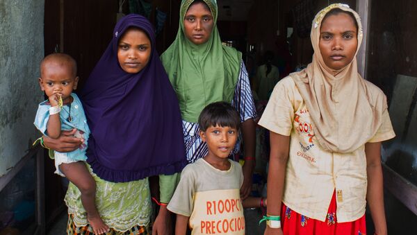 In this photograph taken on May 28, 2015, Rohingya migrant women from Myanmar (L-R) Rubuza Hatu, 21, Rehana Begom, 24 and Rozama Hatu, 23, stand at a confinement camp at Bayeun district in Indonesia's Aceh province after Indonesian fishermen rescued about 400 Rohingya migrants from Myanmar and Bangladesh from a boat on May 20, 2015 off the eastern coast of Aceh.  - Sputnik International
