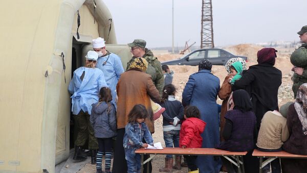 Syria. Treating people at the Jibrin temporary refugee accommodation center in Aleppo. This re-cropped photo courtesy of the Russian Center for Reconciliation of the Warring Parties in Syria - Sputnik International