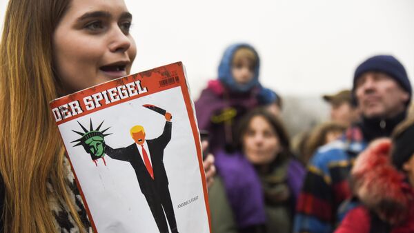 A young woman holds the last edition of Der Spiegel magazine with a cover designed by Edel Rodriguez, as she protests against the travel ban imposed by US President Donald Trump, on February 4, 2017, in Berlin - Sputnik International