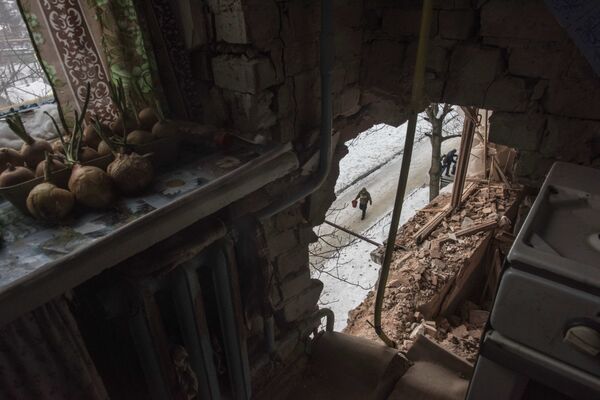 A local resident walking in a street is seen through a hole in an apartment building damaged by shelling in Avdiivka, Ukraine, Saturday, Feb. 4, 2017 A local resident walking in a street is seen through a hole in an apartment building damaged by shelling in Avdiivka, Ukraine, Saturday, Feb. 4, 2017 - Sputnik International