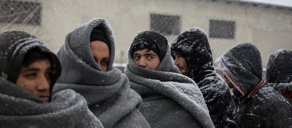 Migrants wait in line to receive free food during a snowfall outside a derelict customs warehouse in Belgrade, Serbia January 9, 2017. Migrants wait in line to receive free food during a snowfall outside a derelict customs warehouse in Belgrade, Serbia January 9, 2017. - Sputnik International
