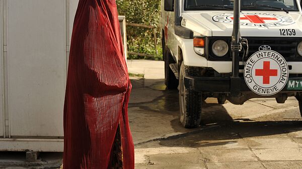 Afghan pedestrain walks past a vehicle at the International Committee for the Red Cross (ICRC) office in Kabul. (File) - Sputnik International