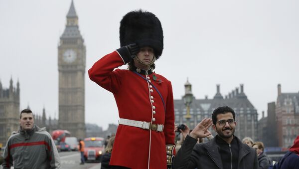 A man on stilts dressed in a ceremonial guardsman costume poses for photographs for tourists as he hands out flyers and collects money for charity on the southern end of Westminster Bridge backdropped by the Houses of Parliament in London, Wednesday, February 8, 2017. - Sputnik International