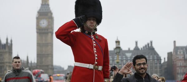 A man on stilts dressed in a ceremonial guardsman costume poses for photographs for tourists as he hands out flyers and collects money for charity on the southern end of Westminster Bridge backdropped by the Houses of Parliament in London, Wednesday, February 8, 2017. - Sputnik International