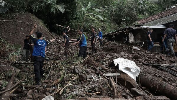 Indonesian villagers and search and rescue team members clear debris as they search for victims of landslide (file) - Sputnik International
