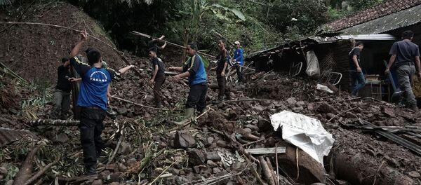 Indonesian villagers and search and rescue team members clear debris as they search for victims of landslide (file) - Sputnik International
