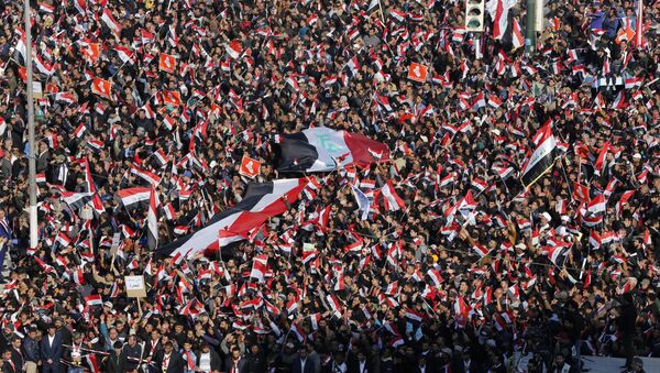 Followers of Iraq's influential Shiite cleric Muqtada al-Sadr chant slogans as they wave national flags during a demonstration against corruption in Baghdad, Iraq - Sputnik International