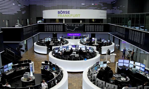 Traders work at their desks in front of the German share price index, DAX board, at the stock exchange in Frankfurt, Germany, January 17, 2017 Traders work at their desks in front of the German share price index, DAX board, at the stock exchange in Frankfurt, Germany, January 17, 2017 - Sputnik International