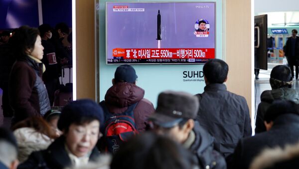 Passengers watch a TV screen broadcasting a news report on North Korea firing a ballistic missile into the sea off its east coast, at a railway station in Seoul, South Korea, February 12, 2017 - Sputnik International