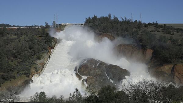 In this Saturday, Feb. 11, 2017, water flows down Oroville Dam's main spillway near Oroville, Calif. - Sputnik International