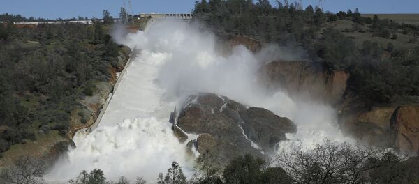 In this Saturday, Feb. 11, 2017, water flows down Oroville Dam's main spillway near Oroville, Calif. - Sputnik International