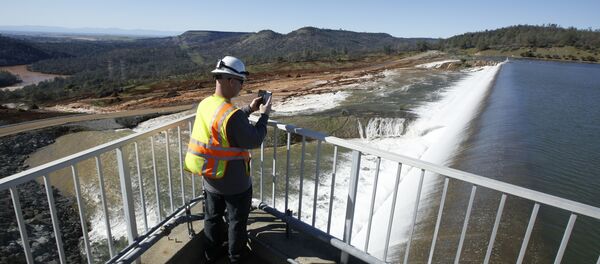 In this Saturday, Feb. 11, 2017, photo, Jason Newton, of the Department of Water Resources, takes a picture of water going over the emergency spillway at Oroville Dam in Oroville, Calif In this Saturday, Feb. 11, 2017, photo, Jason Newton, of the Department of Water Resources, takes a picture of water going over the emergency spillway at Oroville Dam in Oroville, Calif - Sputnik International