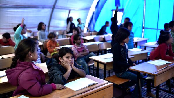 Syrian  children take lessons on November 10, 2014 in a makeshift school tent in a refugee camp in the town of Suruc, Sanliurfa province (File) - Sputnik International