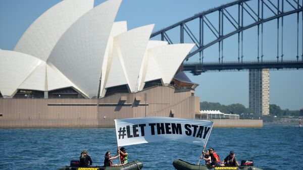 Members of the environmental group Greenpeace hold up a sign that reads #LET THEM STAY in front of the Opera House in Sydney on February 14, 2016. - Sputnik International
