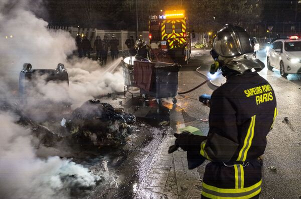 Firefighters extinguish garbage containers set ablaze during the unrest following a protest against police brutality in the Paris suburb of Bobigny. file photo  - Sputnik International