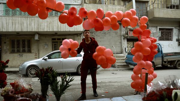 A Syrian man arranges balloons in front of a shop selling Valentine's day gifts in the northeastern city of Qamishli on February 13, 2017 - Sputnik International