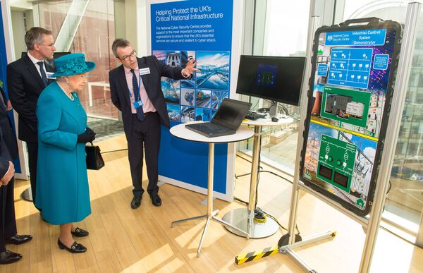 Britain's Queen Elizabeth II (2L) listens as Director of Engagement and Advice Alex Dewdney (R) explains how an electricity supply could be subjected to cyberattack, as she attends the opening of the National Cyber Security Centre in London on February 14, 2017. Britain's Queen Elizabeth II (2L) listens as Director of Engagement and Advice Alex Dewdney (R) explains how an electricity supply could be subjected to cyberattack, as she attends the opening of the National Cyber Security Centre in London on February 14, 2017. - Sputnik International