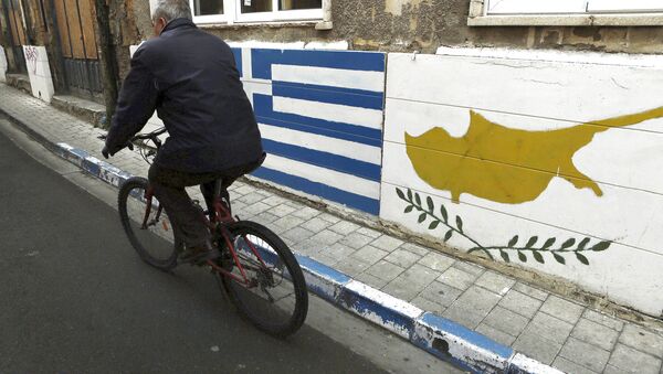 A man passes with a bicycle outside of a Greek Cypriot guard post with Cyprus', right, and Greece' flags painted on the wall in central divided capital Nicosia in the eastern Mediterranean island of Cyprus, on Thursday, Feb. 16, 2017. - Sputnik International