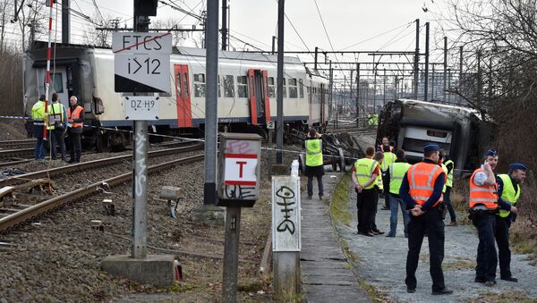 Rescuers and police officers stand next to the wreckage of a passenger train after it derailed in Kessel-Lo near Leuven, Belgium - Sputnik International